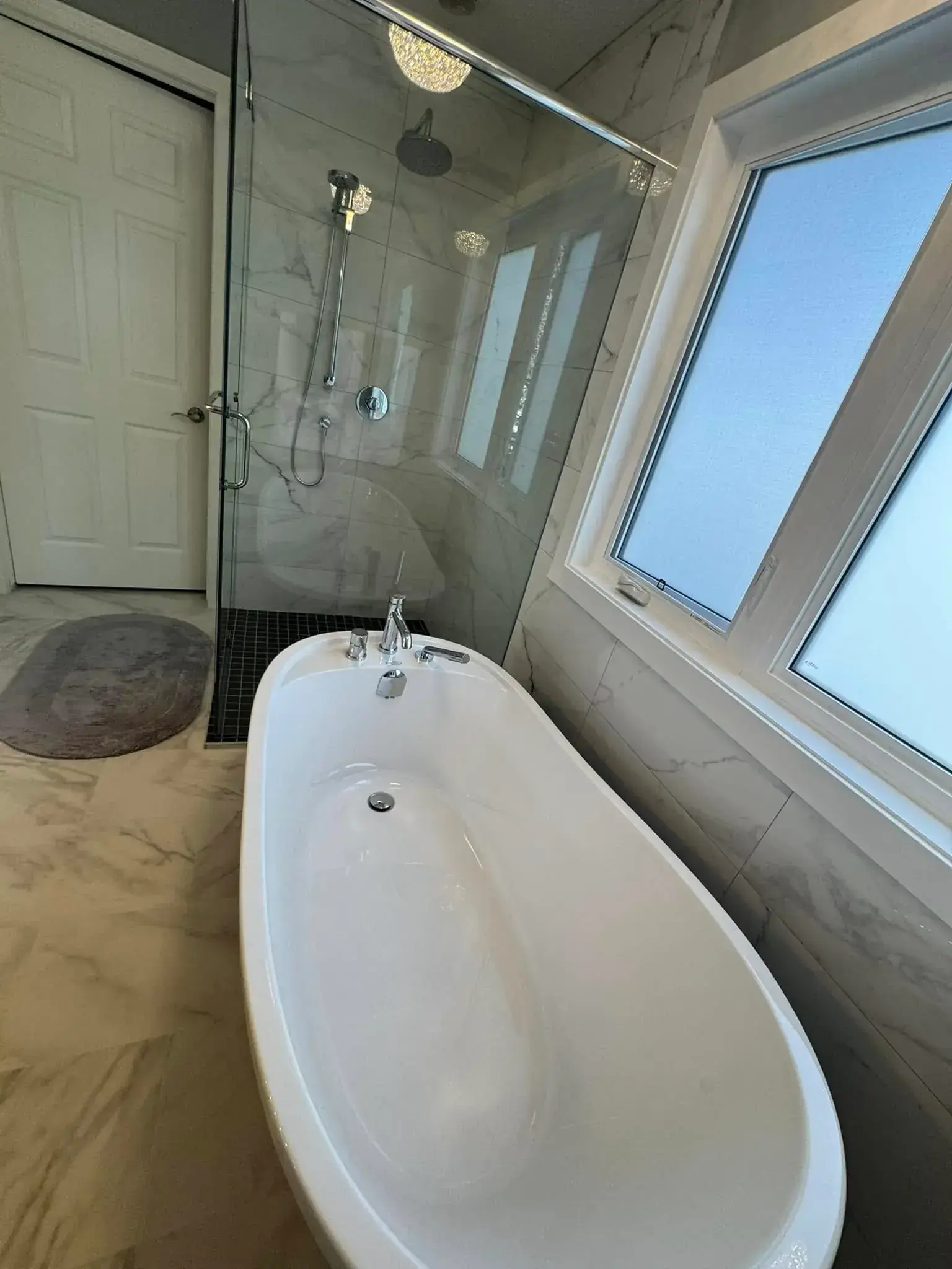 Modern master bathroom with white subway tile, floating vanity, and chrome fixtures in Calgary