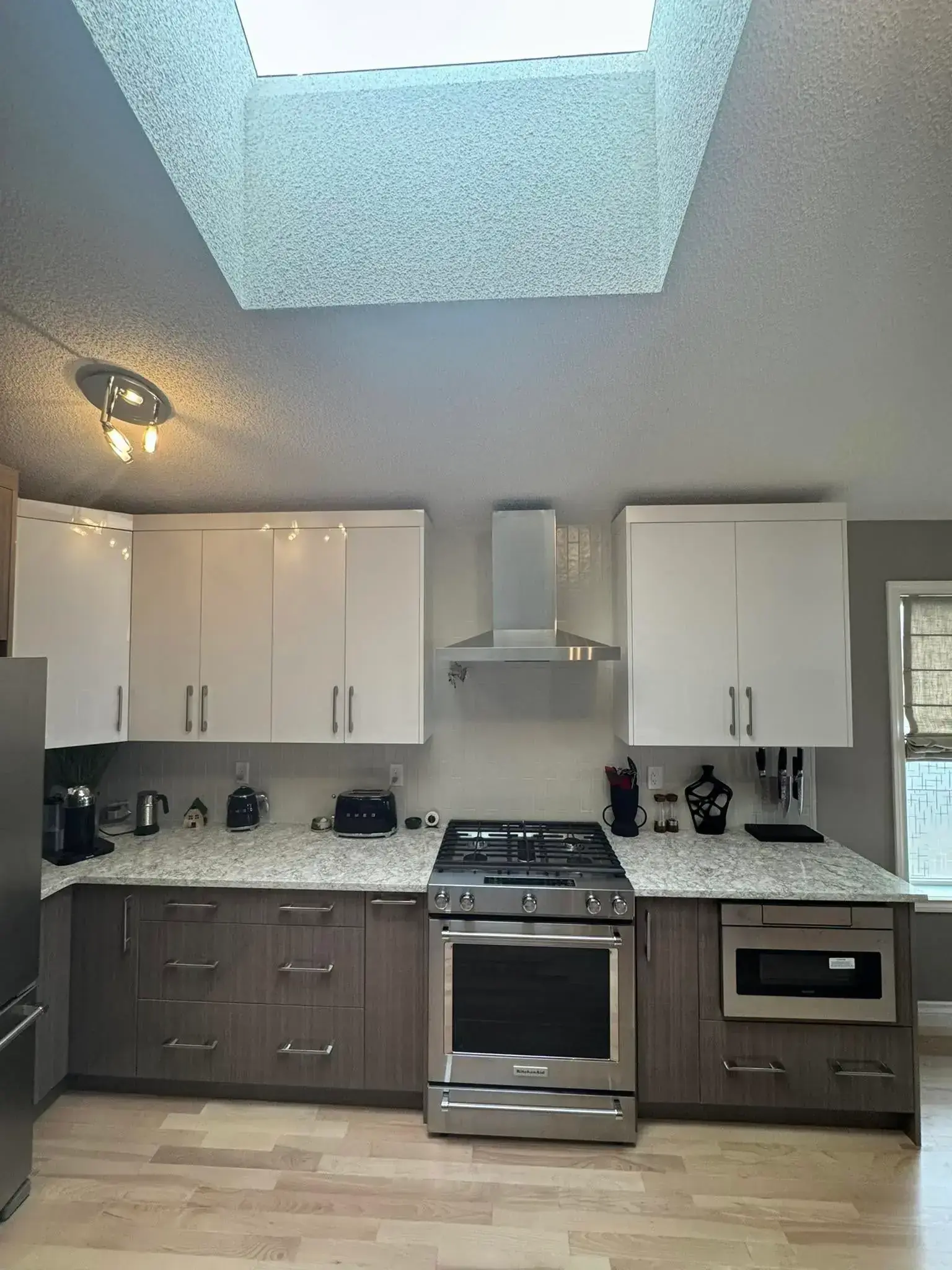 Open concept kitchen with large island, pendant lights, and modern backsplash