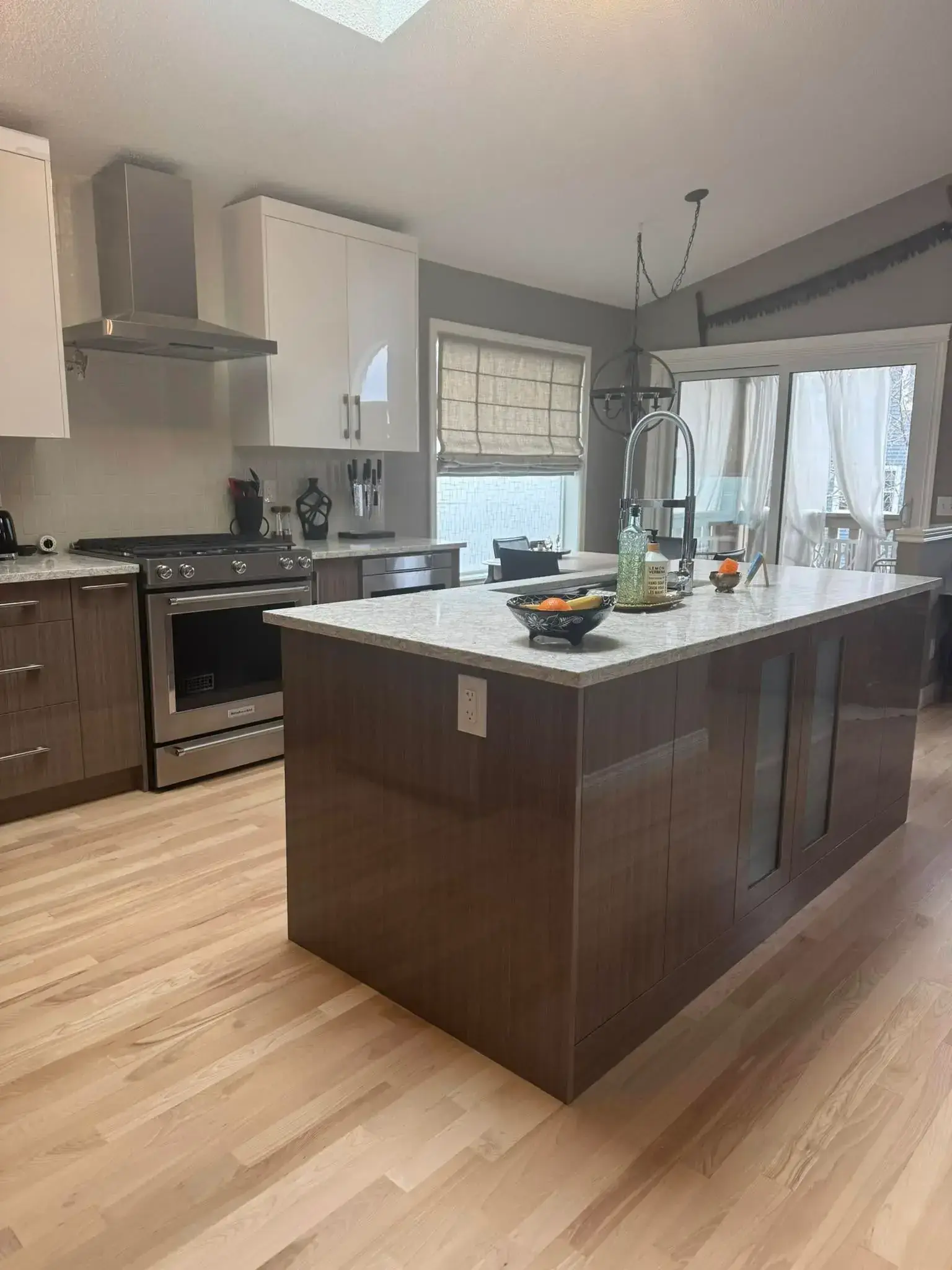 Renovated kitchen with two-tone cabinets, marble backsplash, and modern finishes